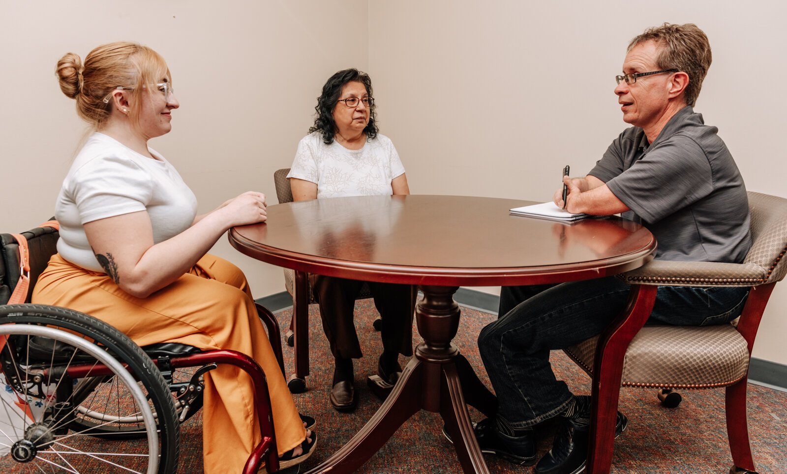 From left: John Guingrich, Moriah Backhaus, and Sylvia Adams have a work meeting at The League For the Blind - Disabled.