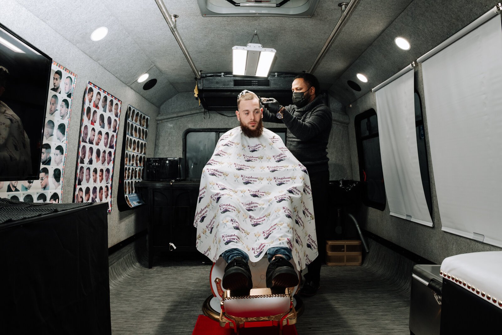 Elgien Richardson, owner of Kingdom Crowns Mobile Barbershop, works on giving client Larry Slater a bald fade & beard clean-up/line-up.