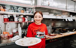Server Sheila Williams serves a plate of country sausage gravy and biscuits with a side of bacon at Cindy's Diner, 230 W. Berry St.