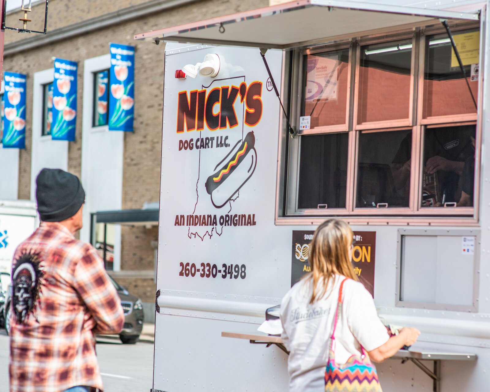 Customers waiting for all-beef hot dogs from Nick's Hot Dog Cart.