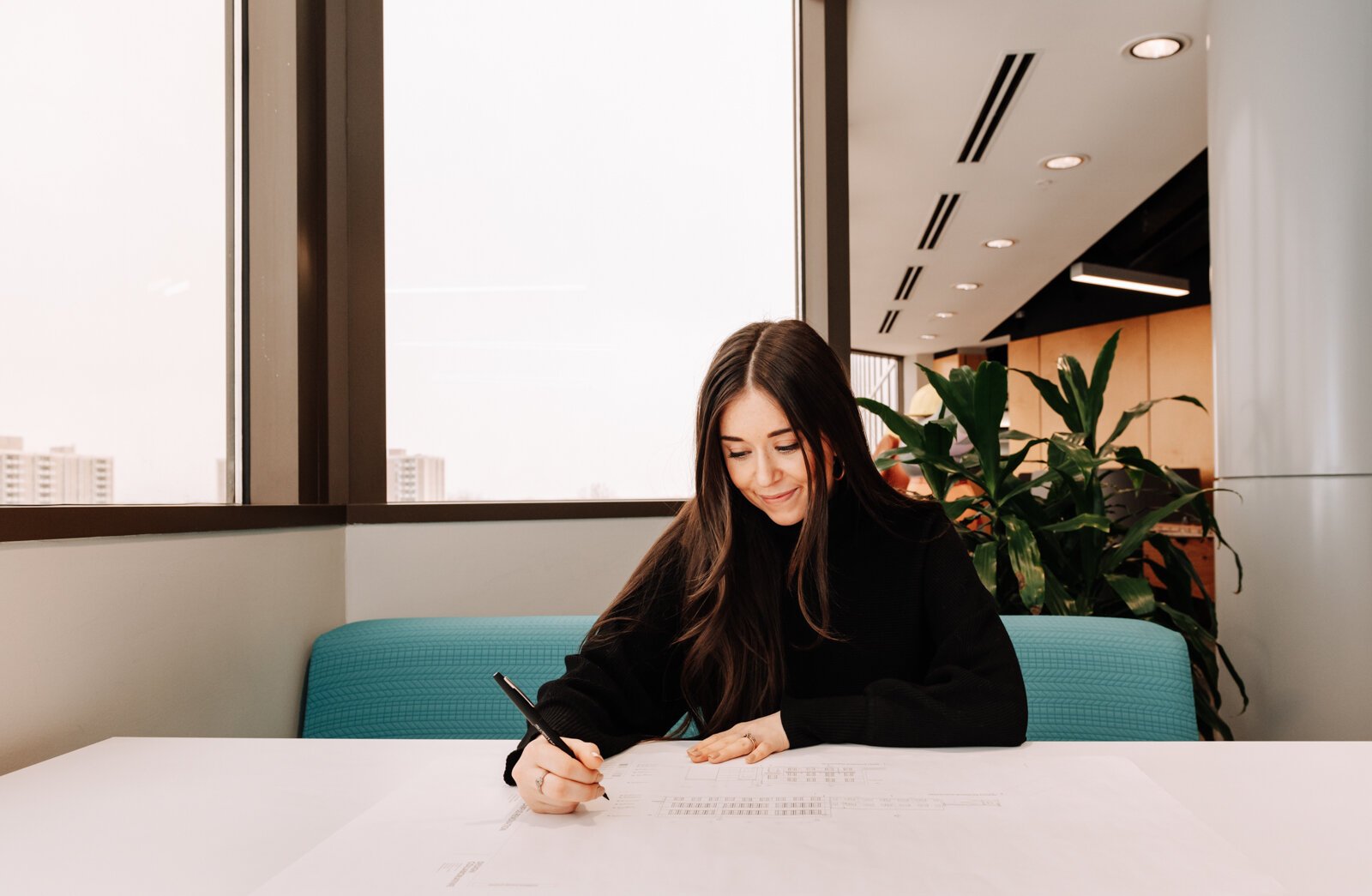 Olivia Yourdon looks over floor plans while in the community hub area at Design Collaborative.