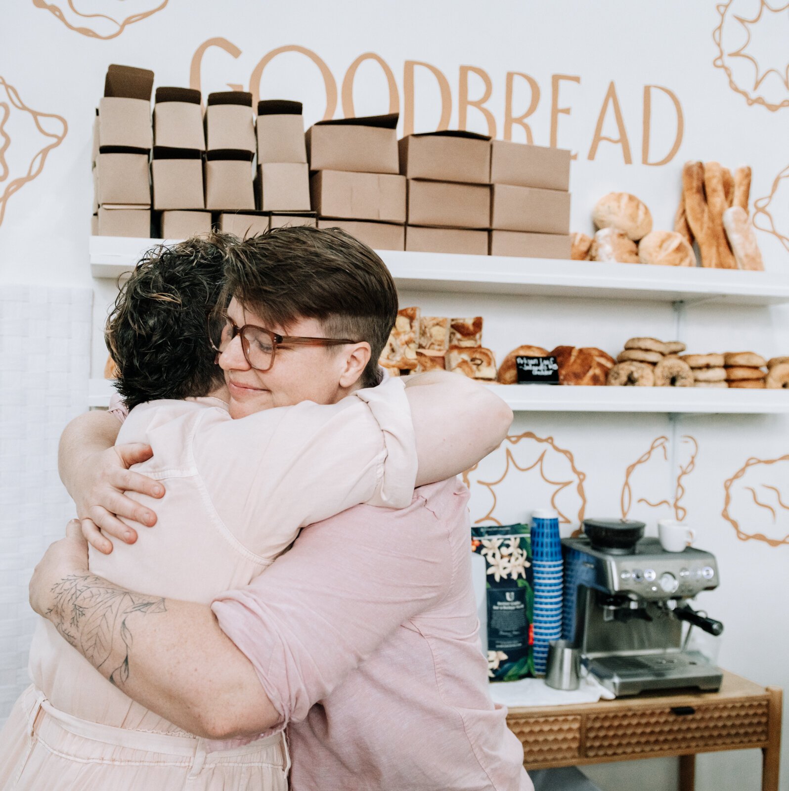 Owner Sarah Thompson, left, and her wife, Hilary Hontz, celebrate after cutting the official ribbon during the grand opening of Good Bread for All.