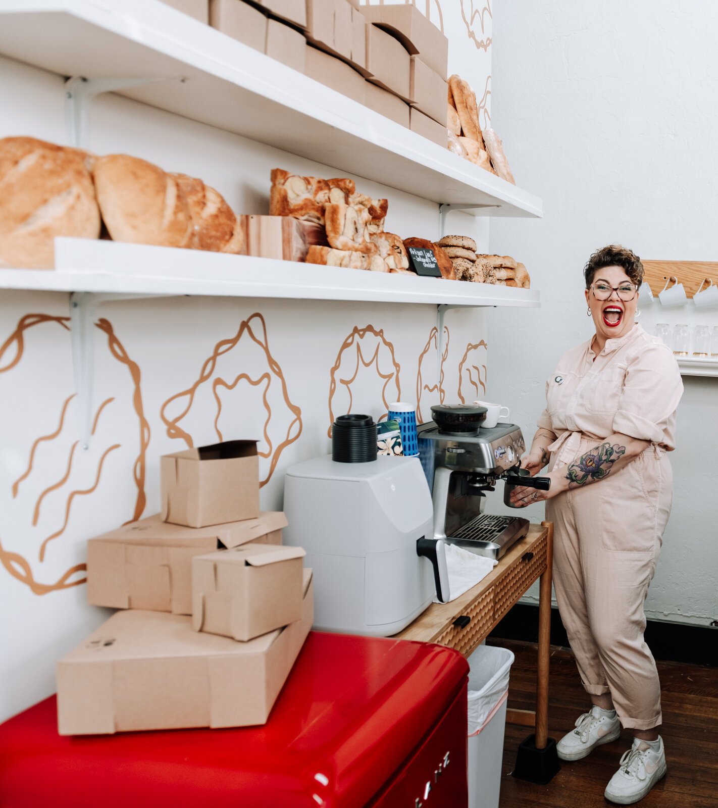 Owner Sarah Thompson makes a coffee for a customer during the grand opening of Good Bread for All.