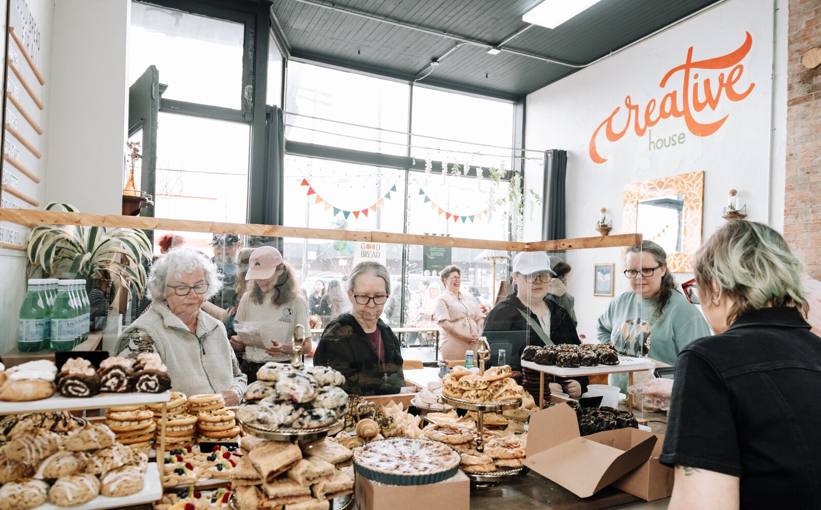 Customers look at Good Bread for All's selection of baked goods.