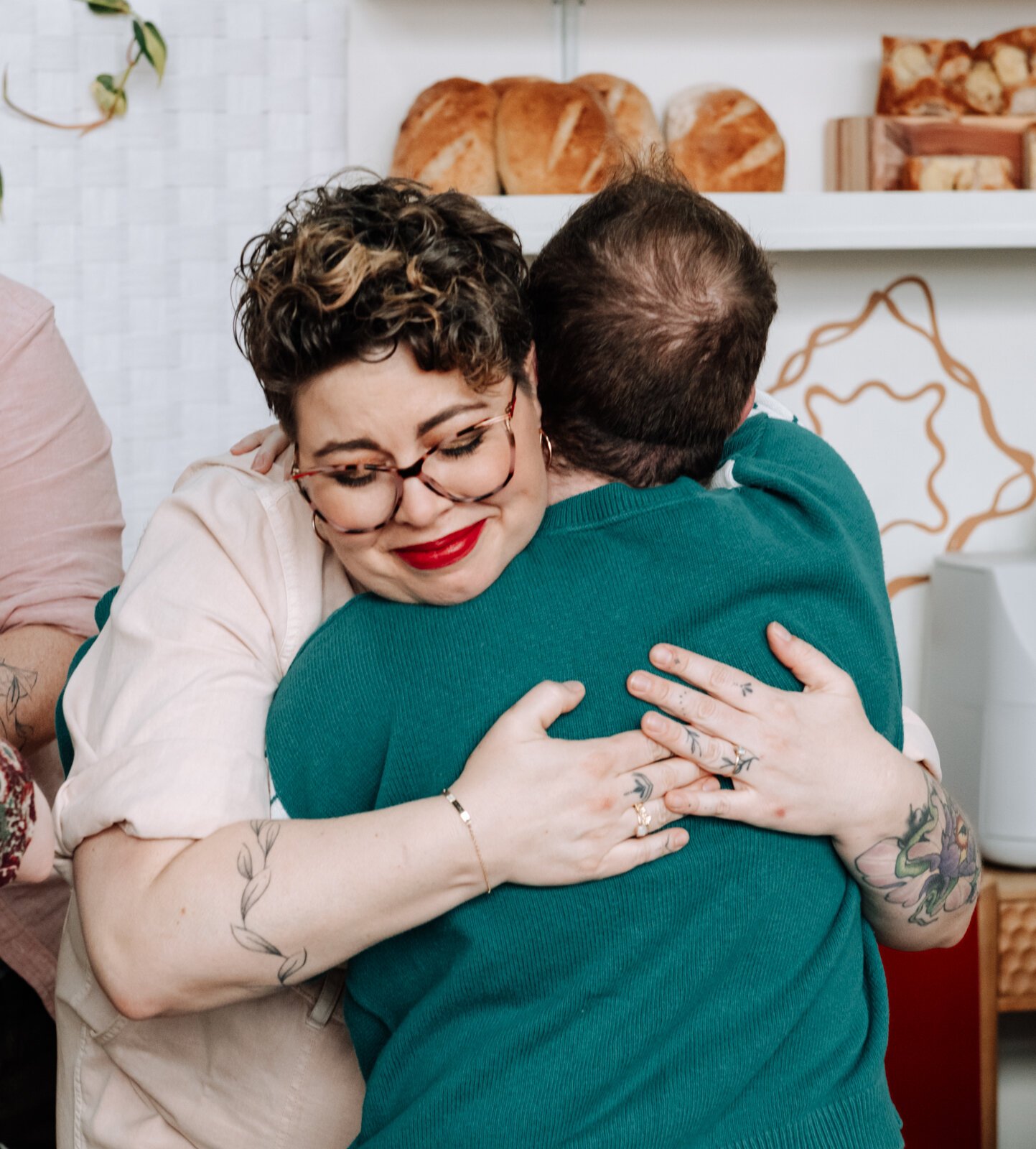 Owner Sarah Thompson hugs customer Eden Bailey during the grand opening of Good Bread for All.