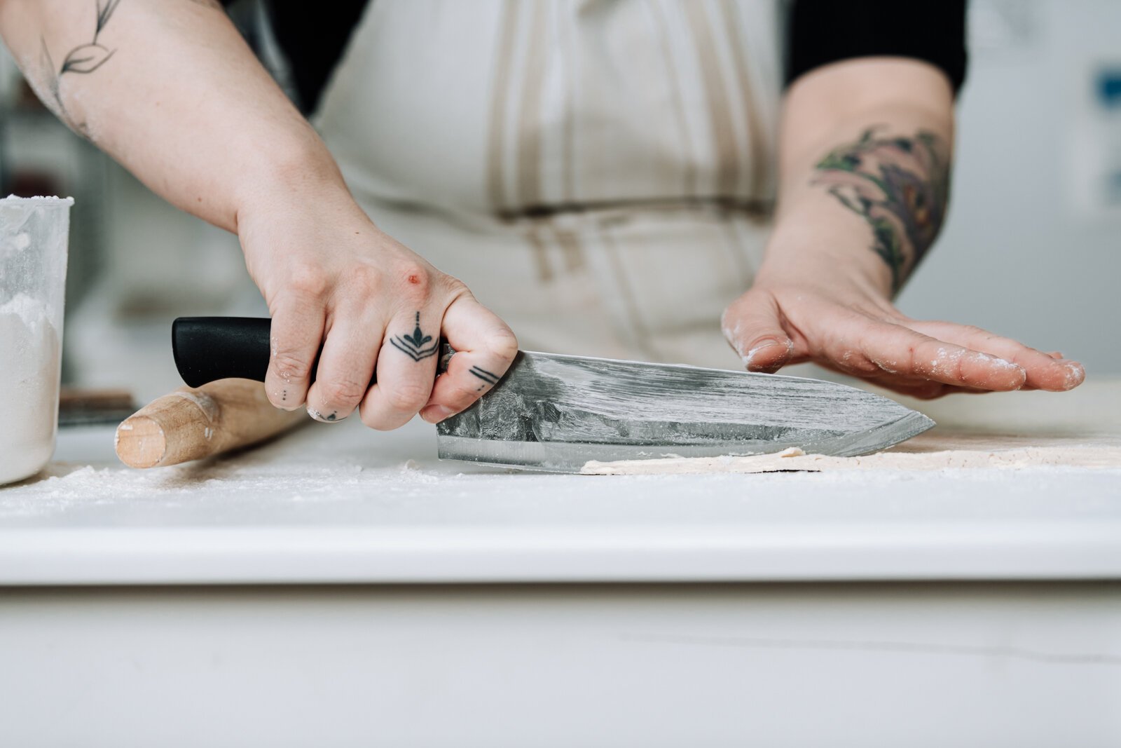 Owner Sarah Thompson works on cleaning up the edges of her croissants.