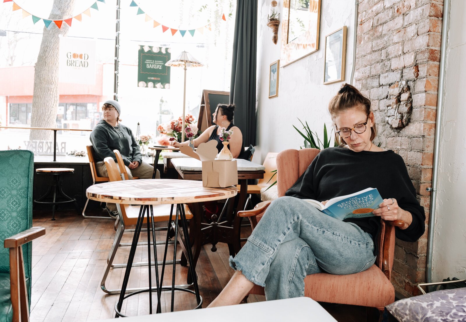 Ann Aylward enjoys reading a book while enjoying gluten free treats at Good Bread for All.
