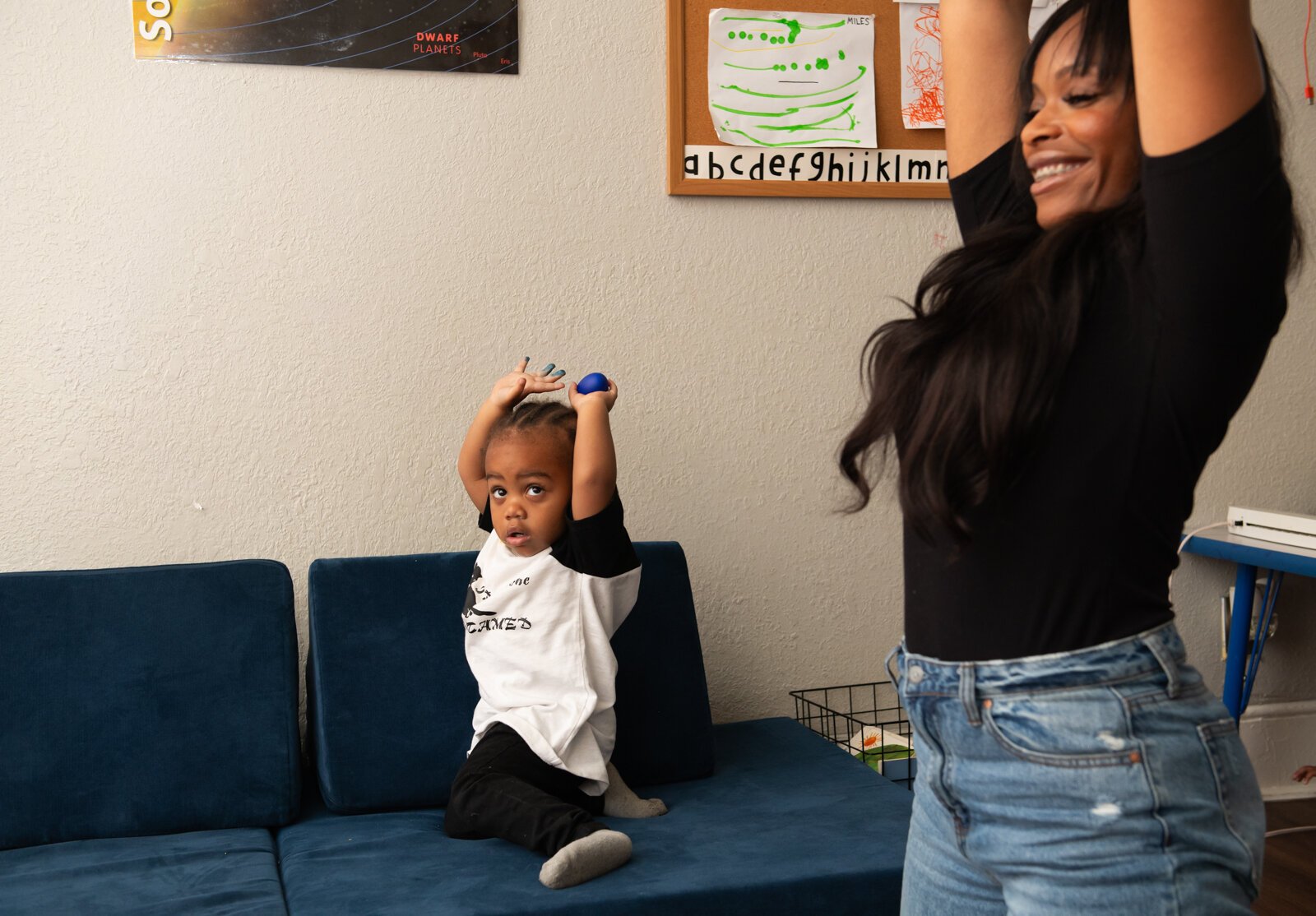 Asir, left, mimics Janae Dubose, owner of Little Achievers Home Daycare Kindergarten Prep, during a toddler yoga activity.