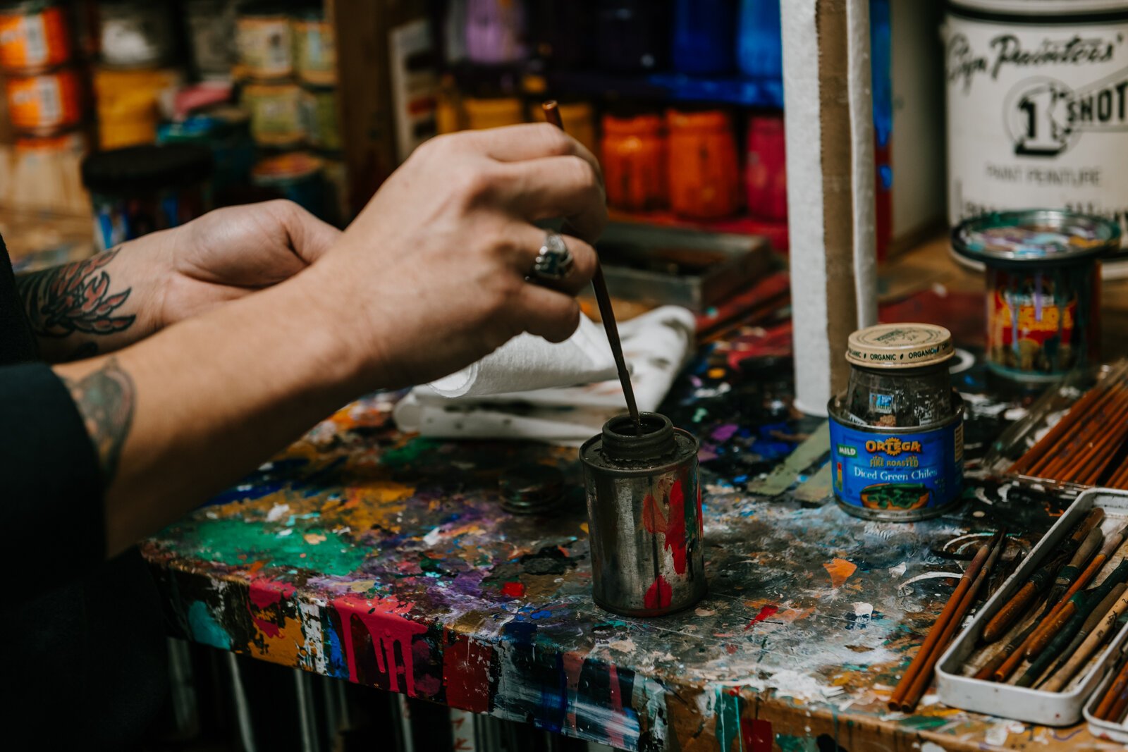 Sign Painter Justin Lim dips his brush in paint.