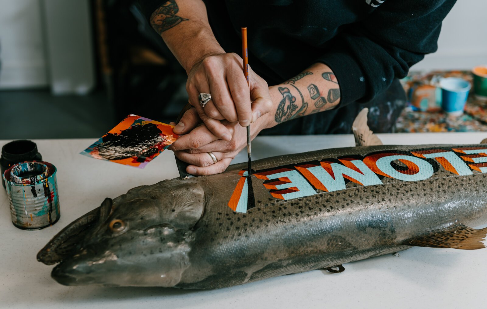 Sign painter Justin Lim, owner of Old 5 and Dime Sign Co., works on a vintage trout taxidermy at his shop in downtown Fort Wayne.