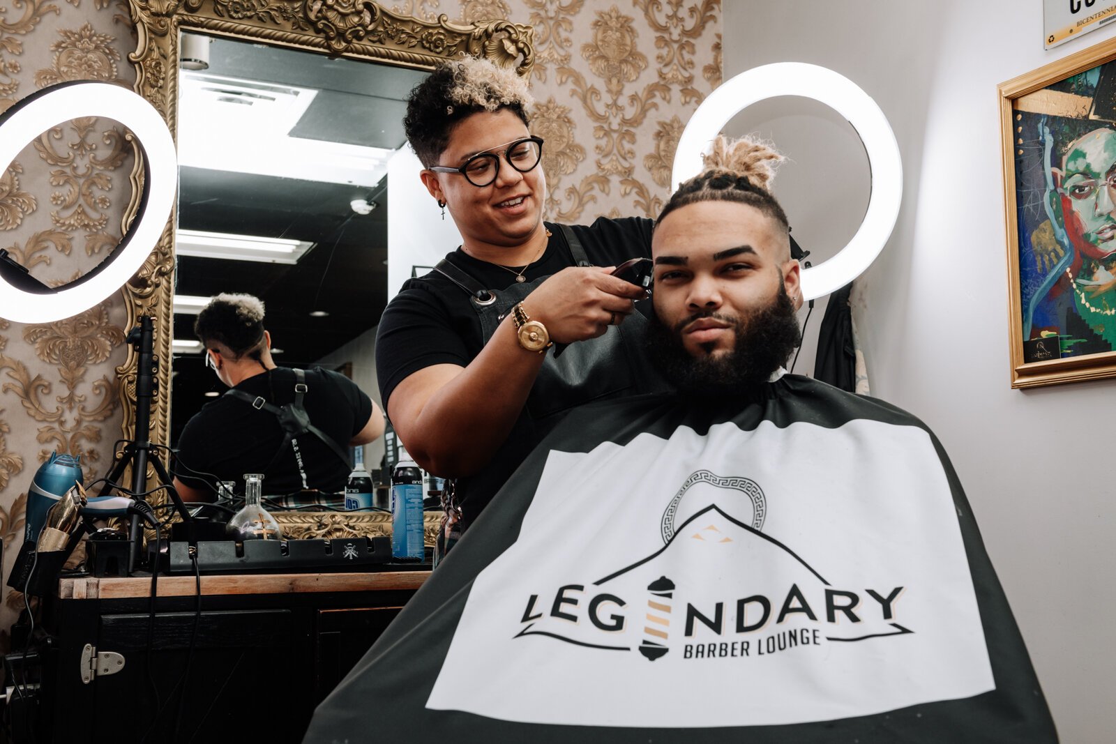 Sasha Chaney, Master Barber and Owner of Legendary Barber Lounge works on giving fellow barber Marcus Chezem a high ball fade with a beard edge up.