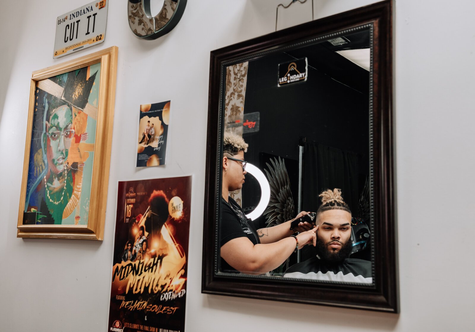 Sasha Chaney, Master Barber and Owner of Legendary Barber Lounge works on giving fellow barber Marcus Chezem a high ball fade with a beard edge up.