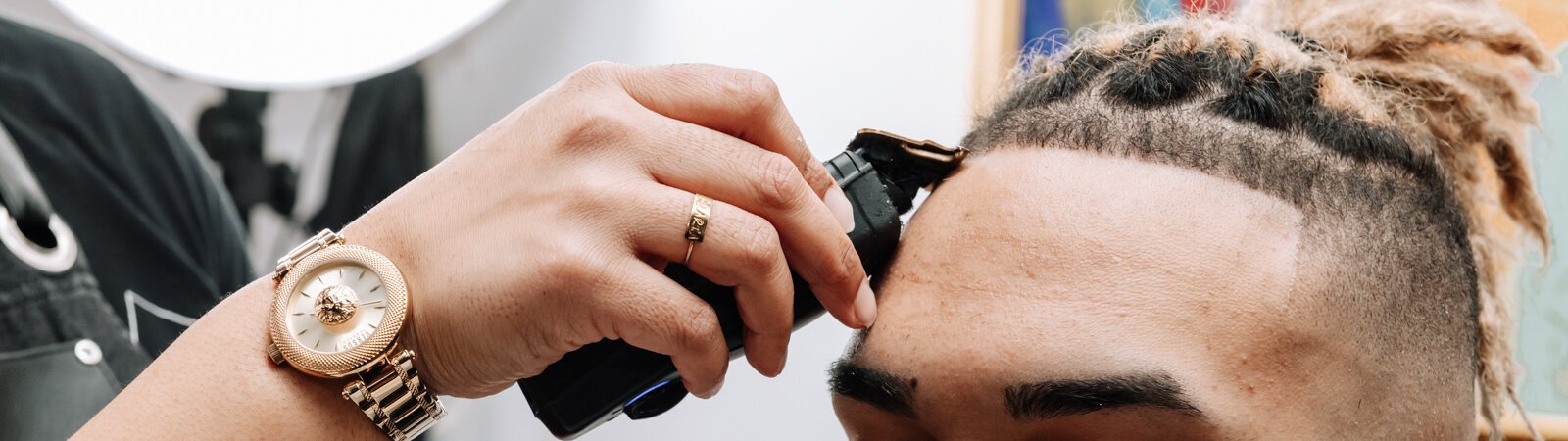 Sasha Chaney, Master Barber and Owner of Legendary Barber Lounge works on giving fellow barber Marcus Chezem a high ball fade with a beard edge up.