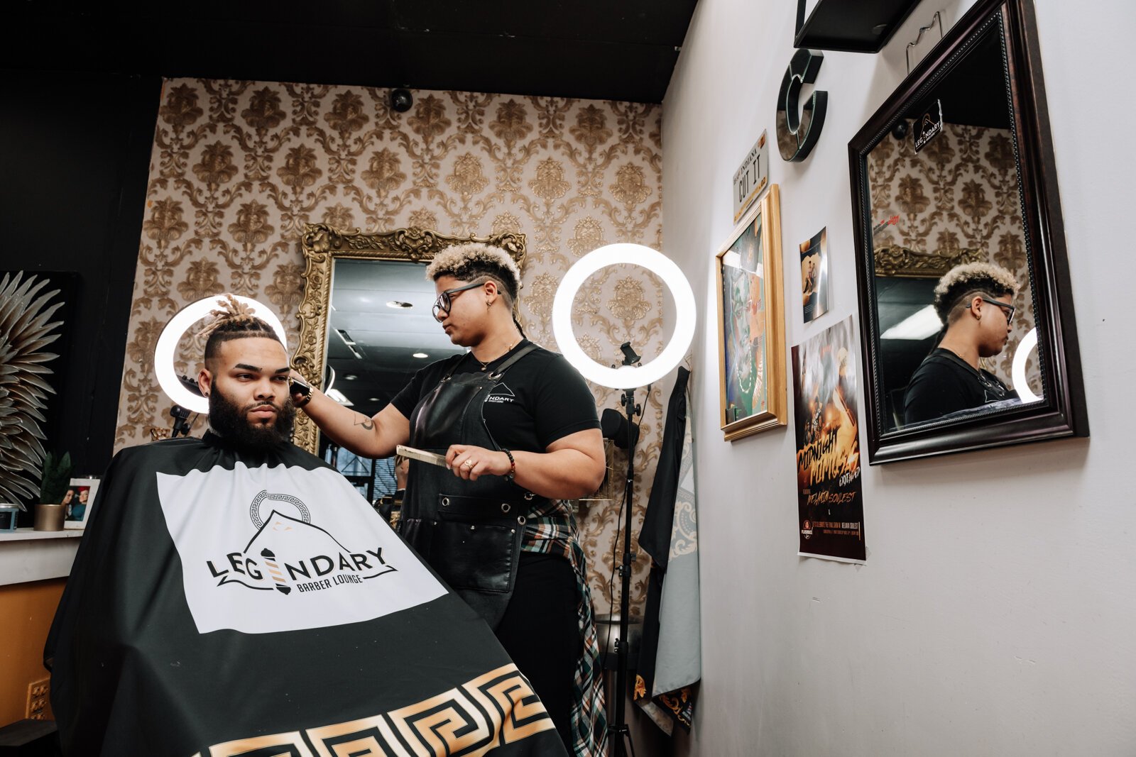 Sasha Chaney, Master Barber and Owner of Legendary Barber Lounge works on giving fellow barber Marcus Chezem a high ball fade with a beard edge up.