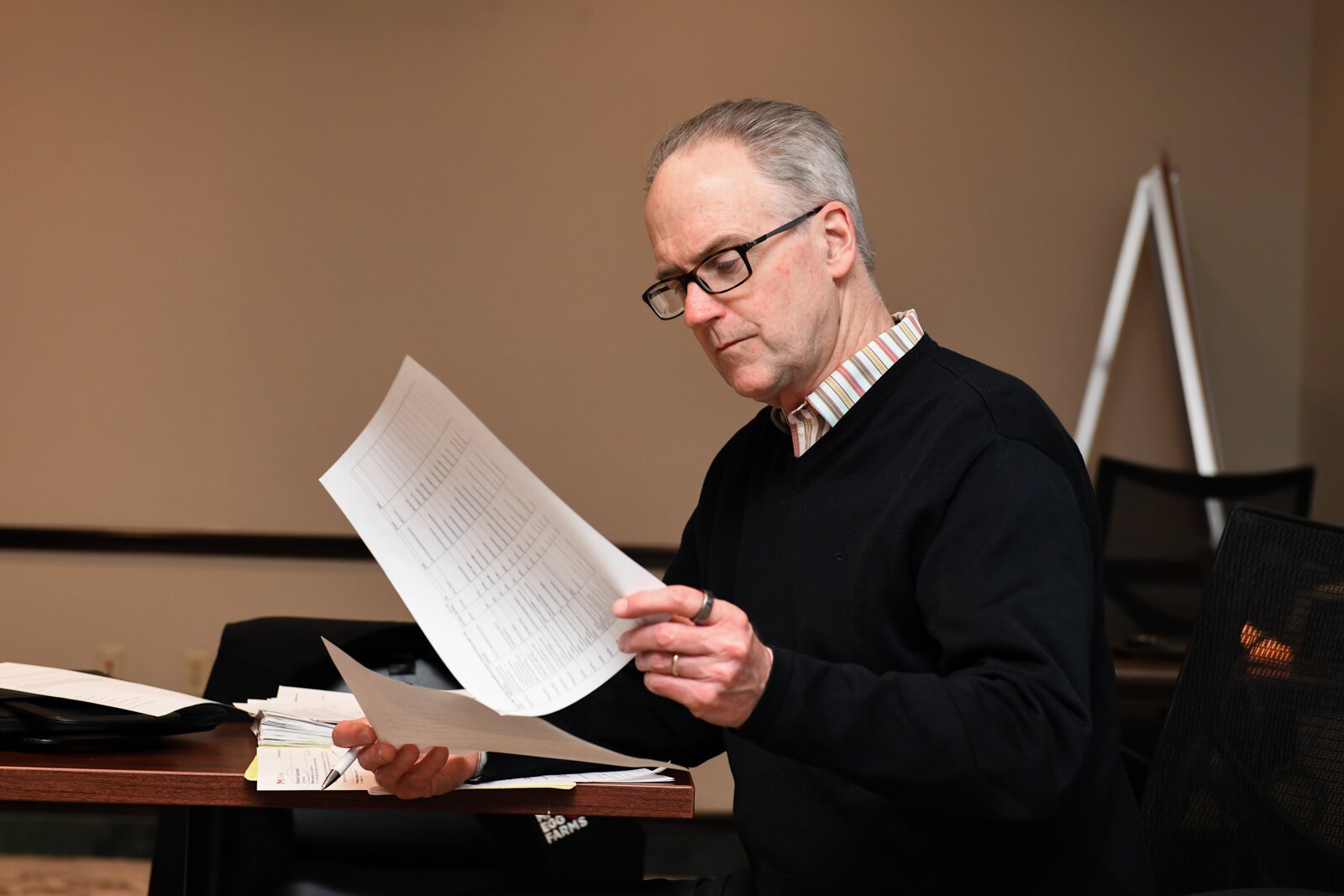 Tim Brown looks at notes during a council meeting with members of the Mayor's Age-Friendly Council at Citizen's Square.