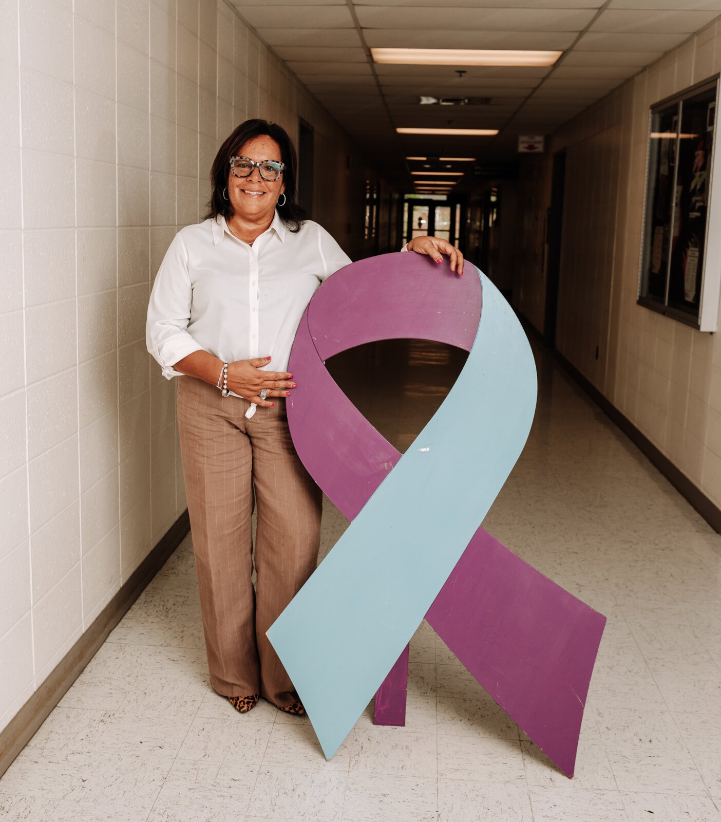 Portrait of Alice Jordan-Miles, Director of Bien Estar Sin Fronteras (Wellness Without Borders) next to the suicide prevention ribbon at Purdue Fort Wayne.