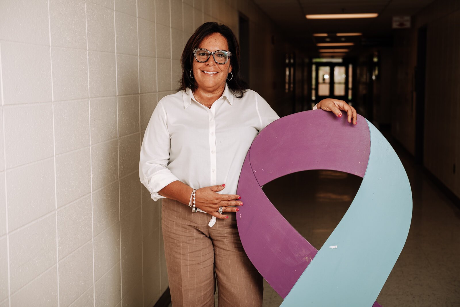 Portrait of Alice Jordan-Miles, Director of Bien Estar Sin Fronteras (Wellness Without Borders) next to the suicide prevention ribbon at Purdue Fort Wayne.