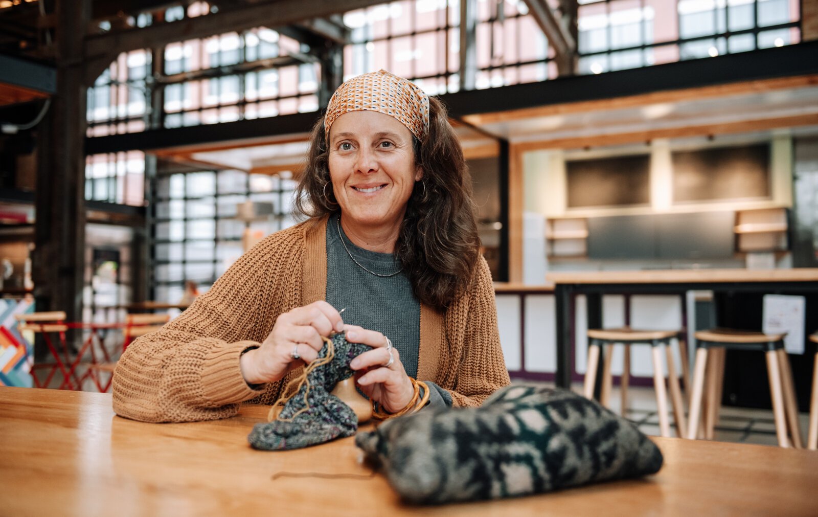 Megan Burton, who started Monday Mendings, works to fix a sock.