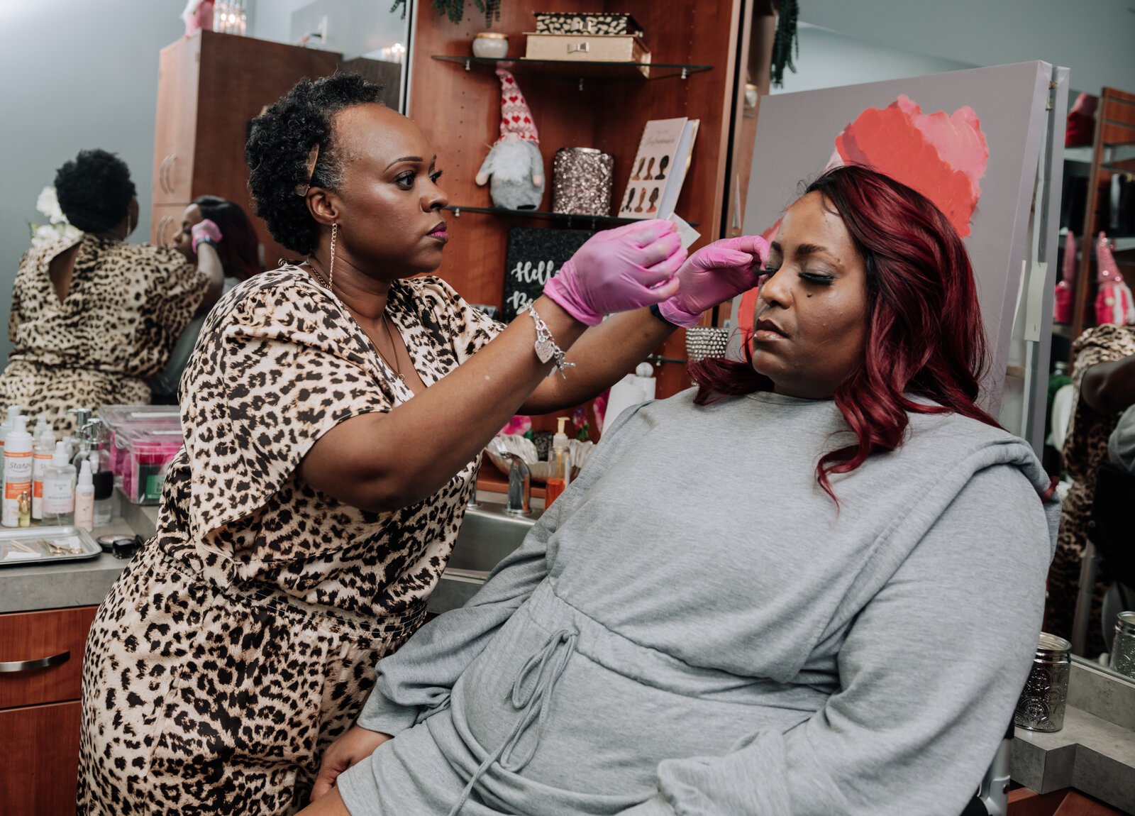 Rohli Booker with Aza Image Beauty & Brow Studio does a brow wax and fill eyebrow service for Toya T. in her studio.