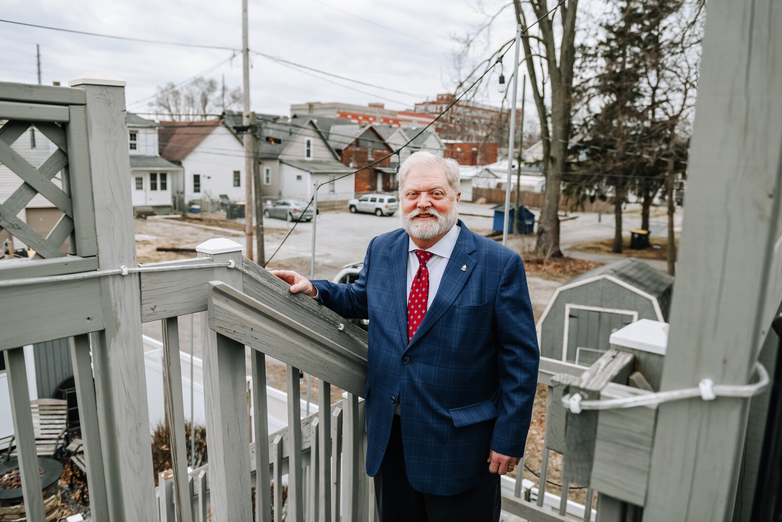 Portrait of Rudy Mahara from the top deck showing neighboring homes and properties at Rudy's Cigar Shop.