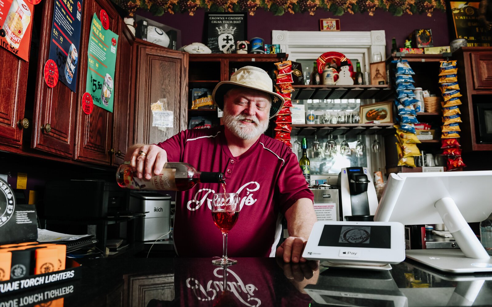 Rudy Mahara pours a glass of Rudy's Indiana Summer table wine made by Country Heritage at Rudy's.