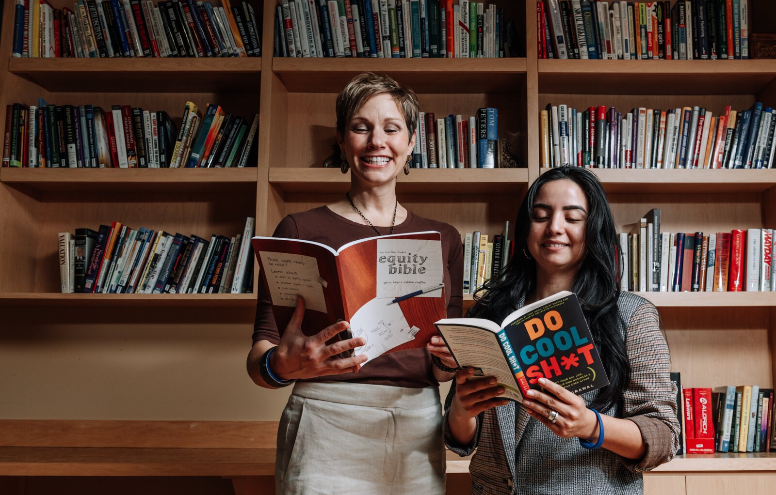 Leslee Hill, left, Program Director and Rosalina Perez, Program Manager at WEOC Women's Business Center show off business books at the Northeast Indiana Innovation Center.