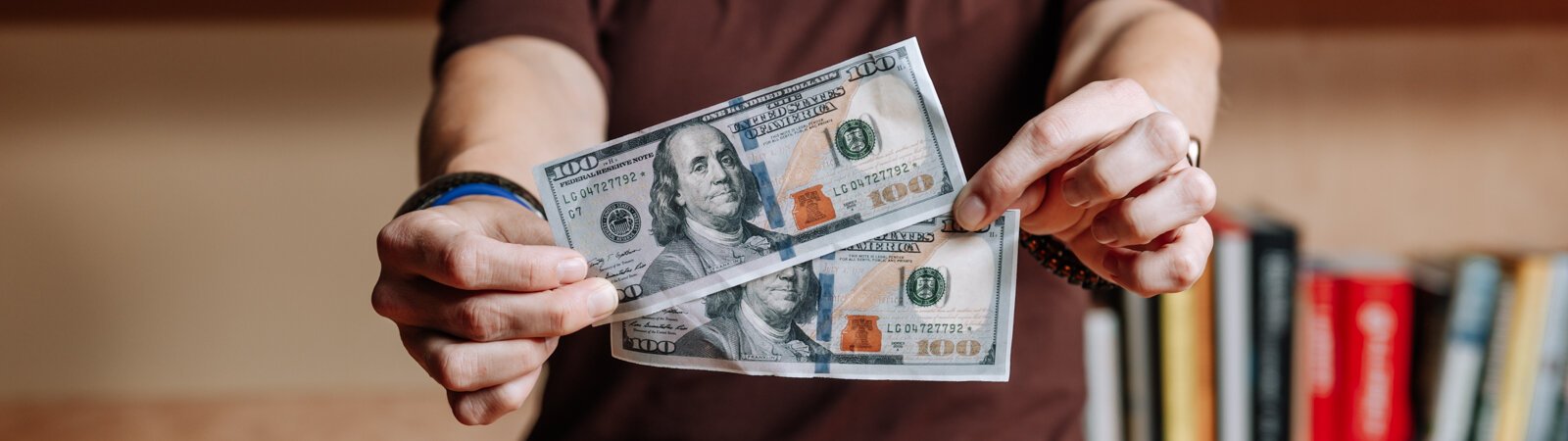 Leslee Hill, Program Director at WEOC Women's Business Center holds up money at the Northeast Indiana Innovation Center.