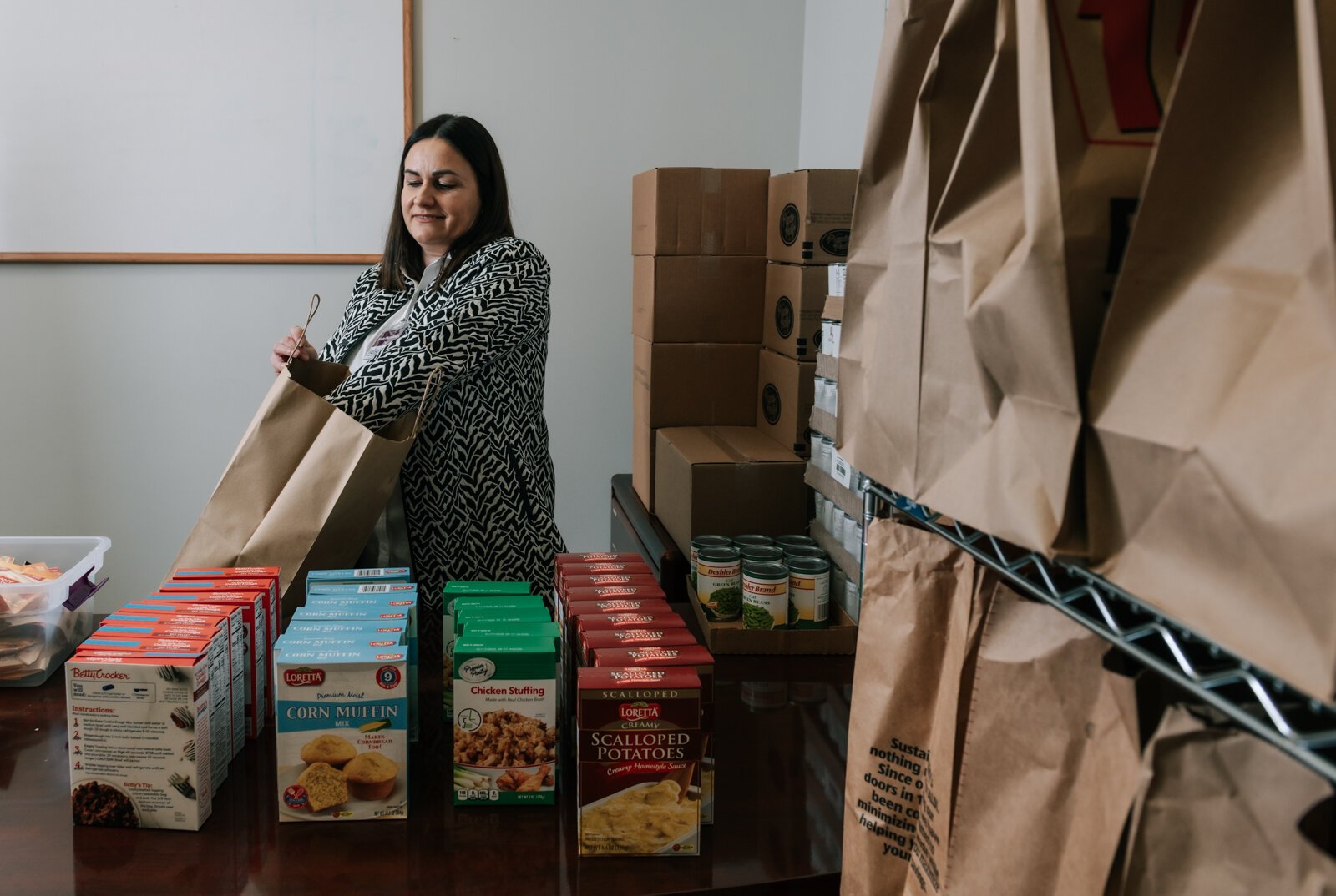 Ermina Mustedanagic, CEO of Wellspring packs a holiday bag at the foodbank at Wellspring Interfaith Social Services.