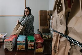 Ermina Mustedanagic, CEO of Wellspring packs a holiday bag at the foodbank at Wellspring Interfaith Social Services.