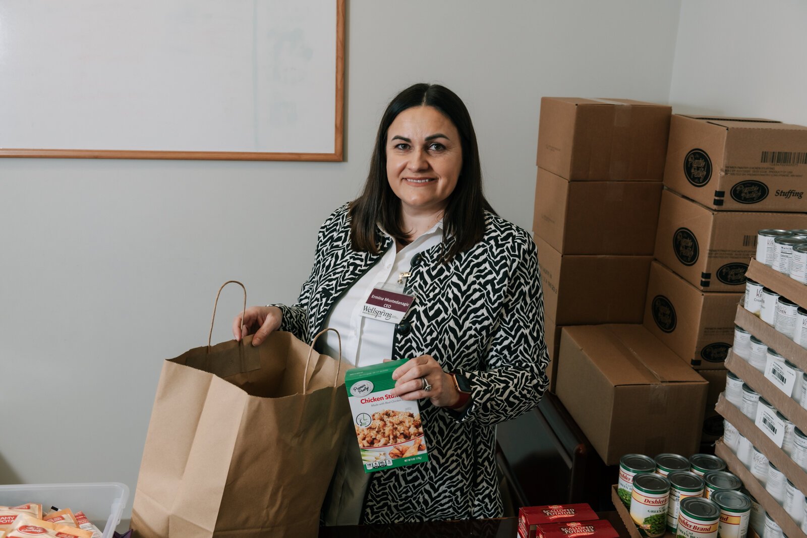 Ermina Mustedanagic, CEO of Wellspring packs a holiday bag at the foodbank at Wellspring Interfaith Social Services.