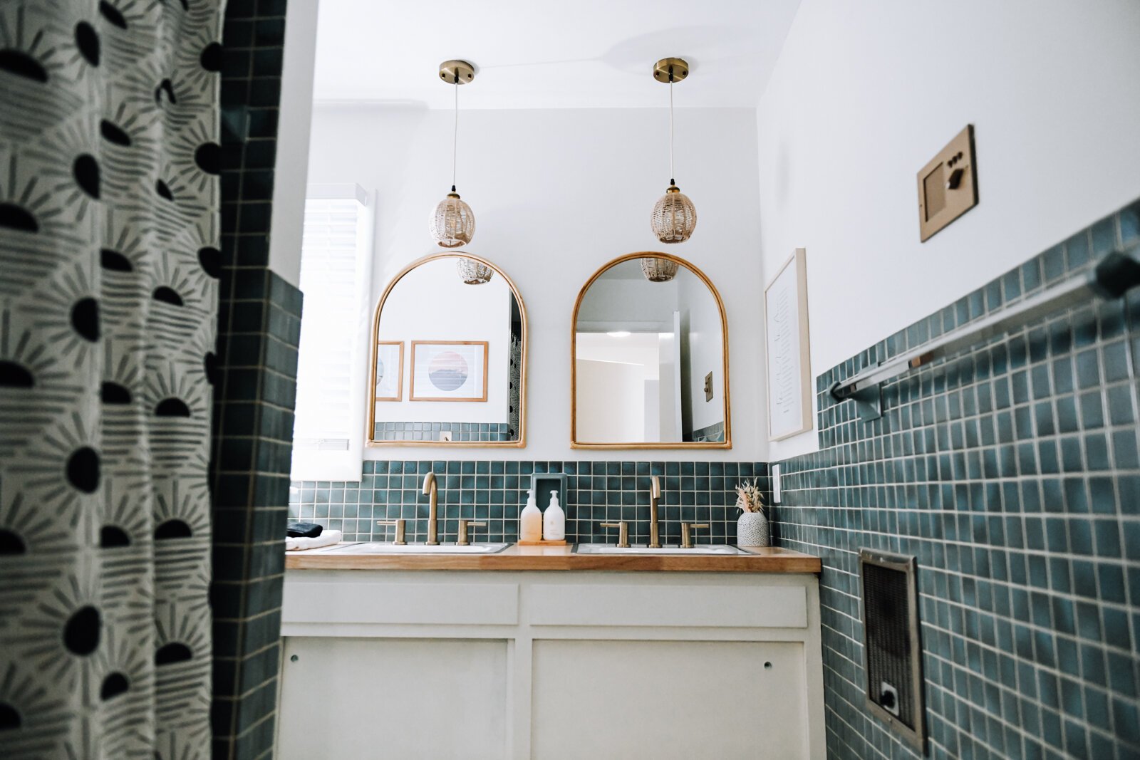 The main bathroom features gold and green tones, mirrors and original tile.