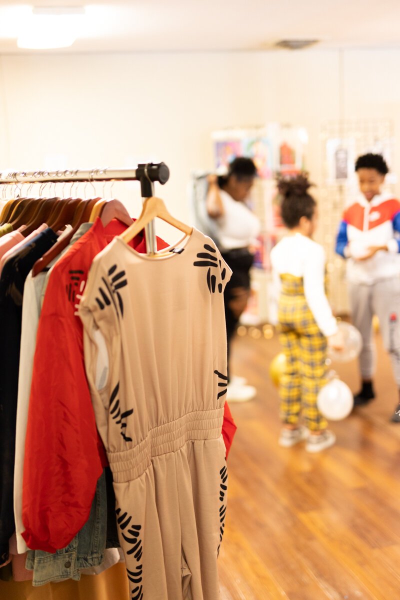 Guests shop Jordan Latham​​​​​​​'s designs for Jola Ariel Art & Boutique at a launch party in Fort Wayne.