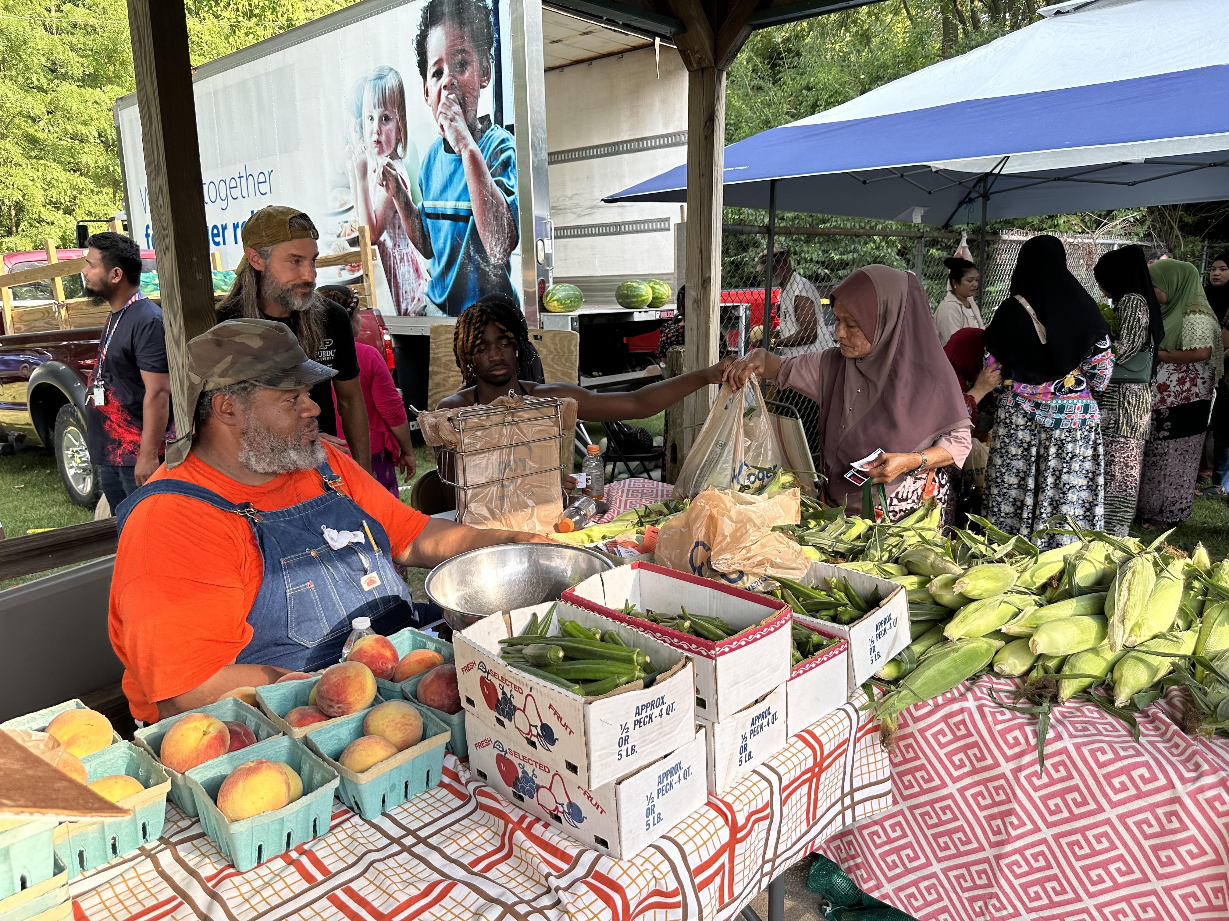 Jered Blanchard with a farmer at the HEAL Market.