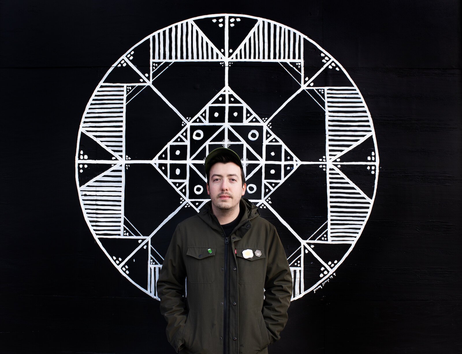 Jeremy Stroup stands in front of his mural at the Brass Rail in Fort Wayne.