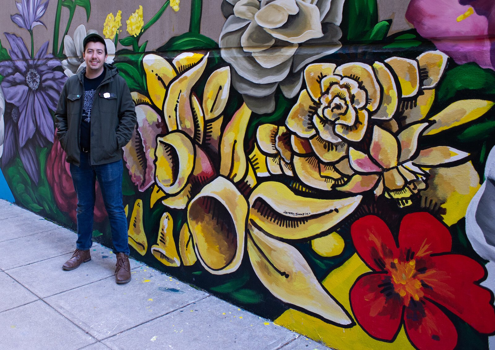 Jeremy Stroup stands in front of his section of the "Hello" mural in the alley at 120 W. Wayne St. in downtown Fort Wayne, led by artist Shawn Dunwoody.