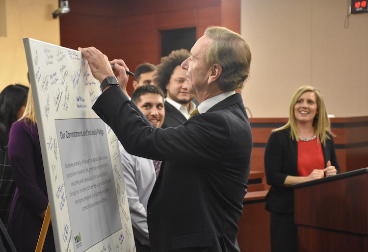 Veit, right, watches as Fort Wayne City Councilman Crawford signs the YLNI Inclusivity Pledge.