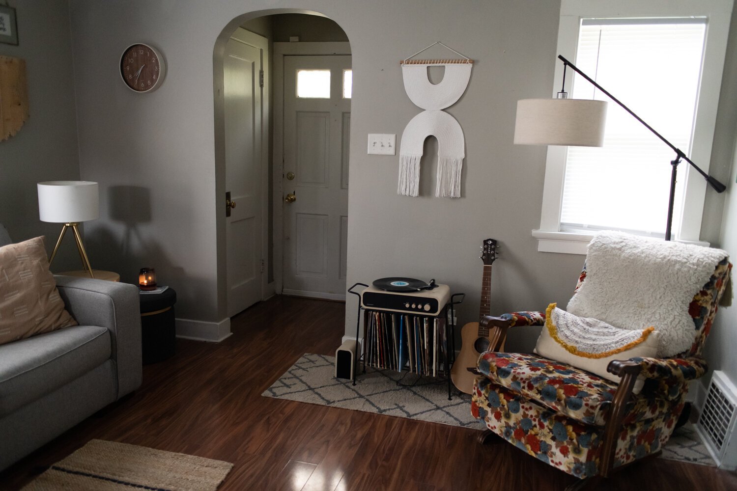 The living room has a modern, bohemian style of decor. 