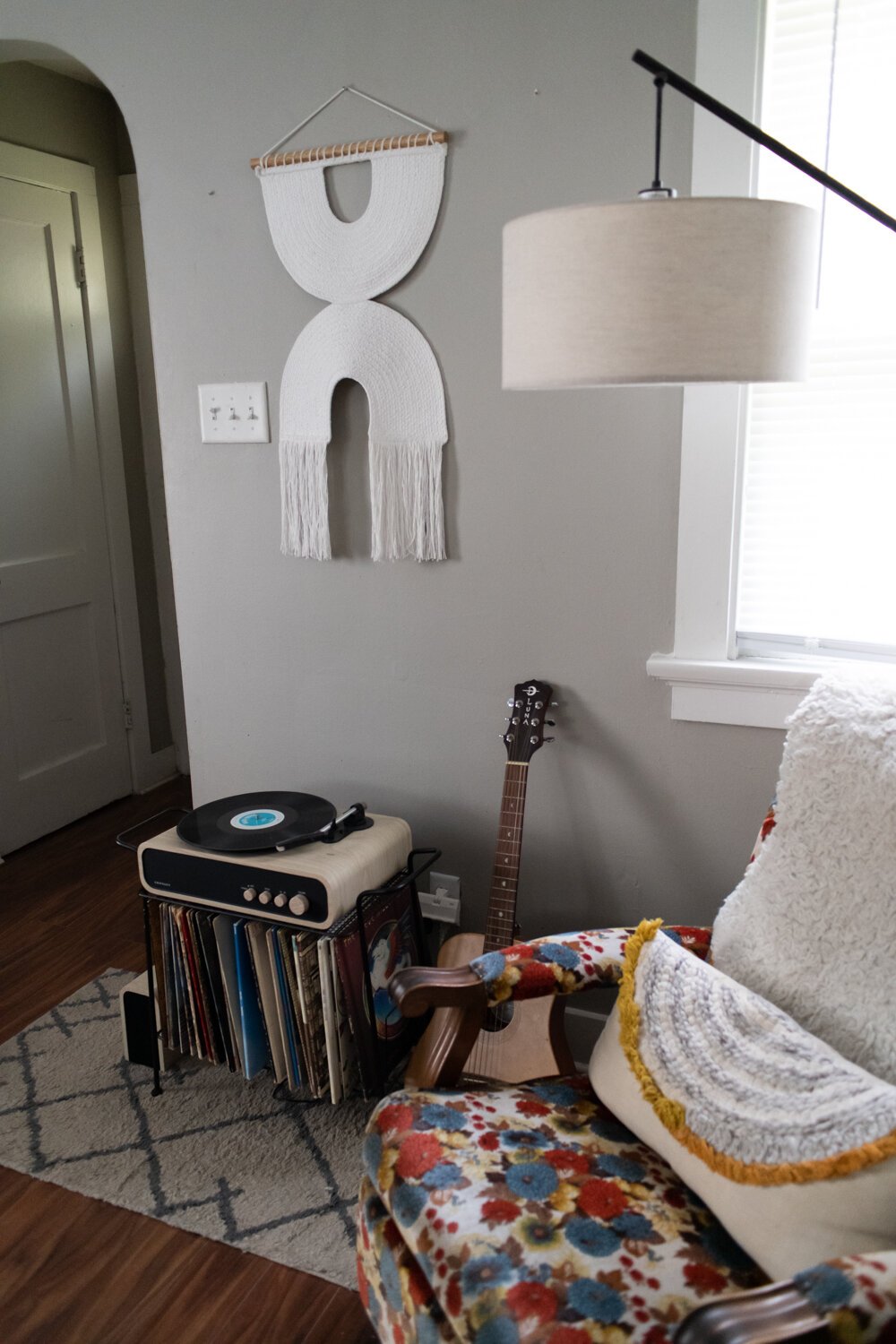 The living room has a modern, bohemian style of decor. 