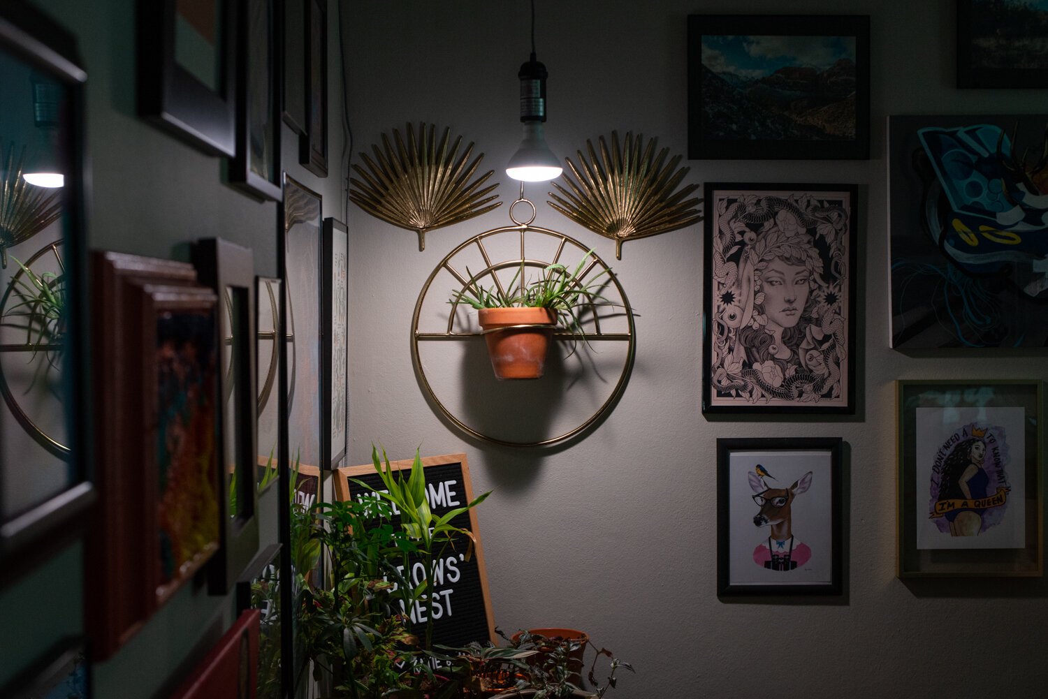A plant holder from Sarah Gaines and decorative fans from a garage sale hang on the wall at the home of Katie Jo and Tobi Newson.