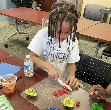 Khaliyah Penson, age 7, and her mom, Kendrea Penson, work together to prepare a meal as part of the Kids in the Kitchen class offered through Parkview.