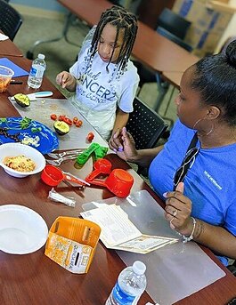 Khaliyah Penson, age 7, and her mom, Kendrea Penson, work together to prepare a meal as part of the Kids in the Kitchen class offered through Parkview.