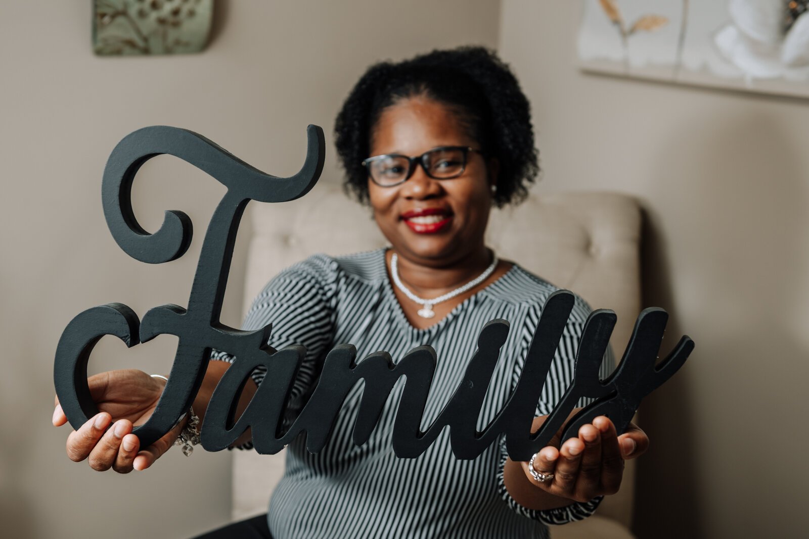 LaQueisha Brown holds up a family sign in her home in Fort Wayne, IN.