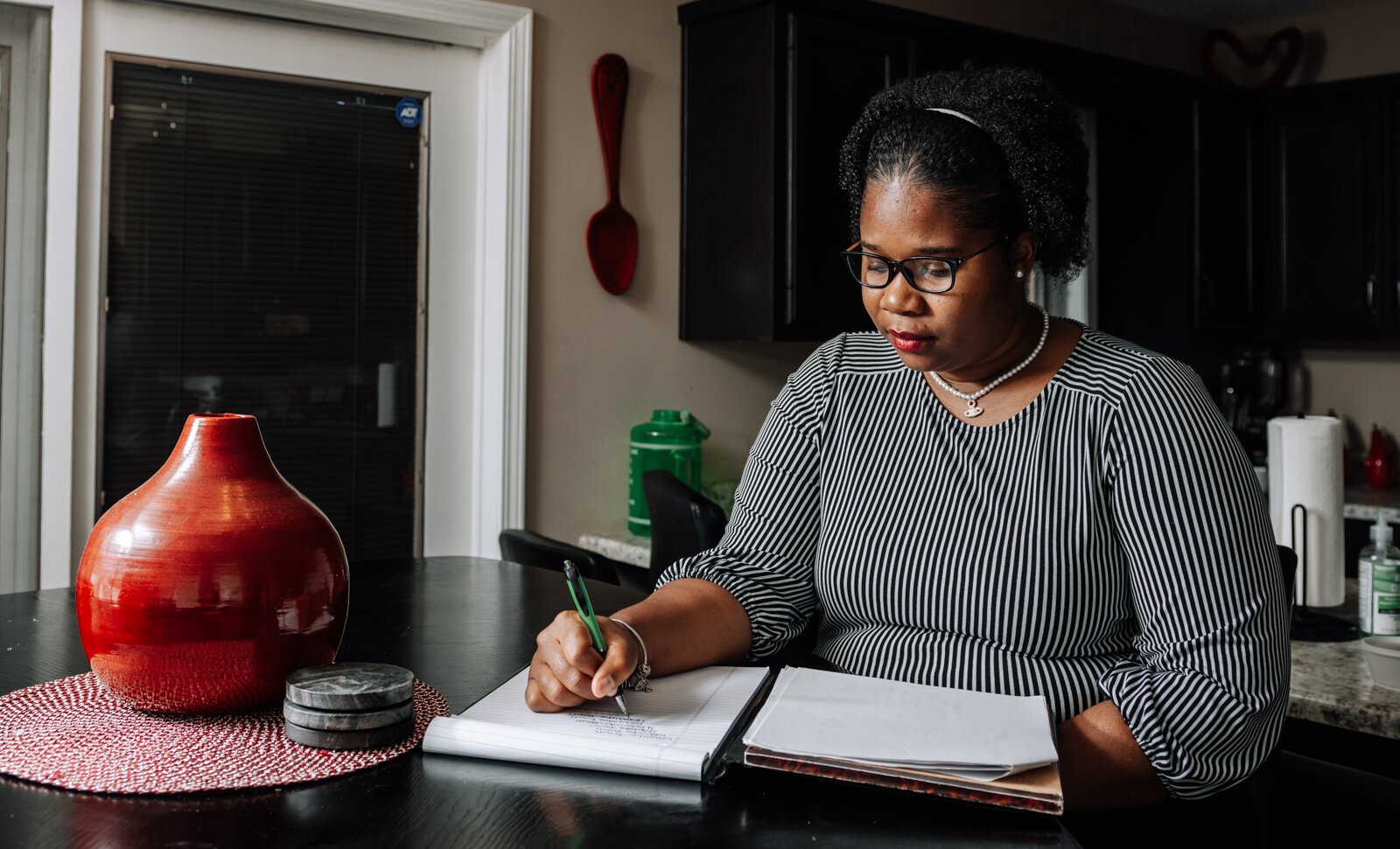 LaQueisha Brown takes work notes in her home.