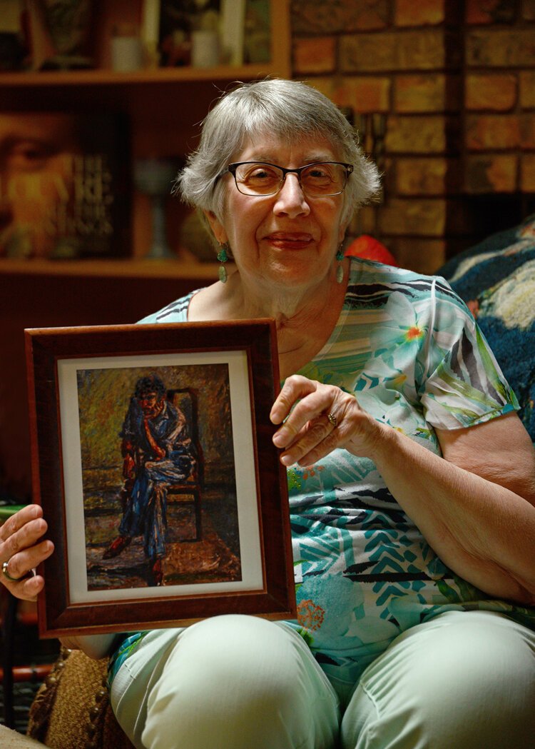 Lenore DeFonso holds artwork by Sufi Ahmad.