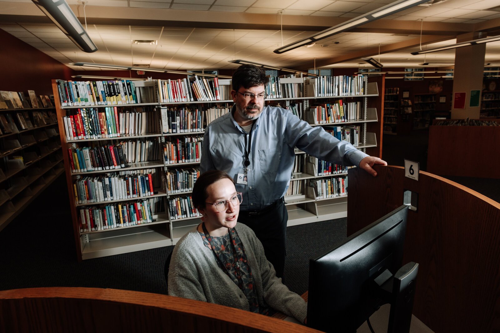 Branch Manager Christopher R. Wiljer helps Librarian Kristina Lay with the computer at the Allen County Public Library's Monroeville branch.