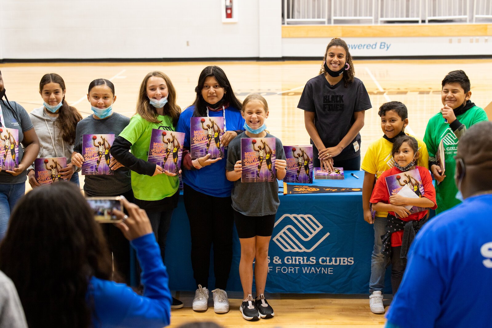 Madison Moore, a Fort Wayne-raised author of "More Than Just a Game: The Black Origins of Basketball," signs copies of her book at the Fort Wayne Boys & Girls Club.