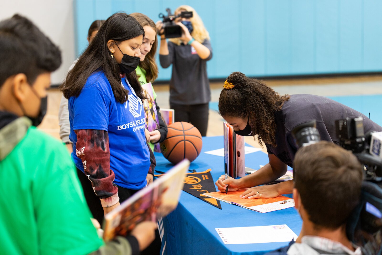 Madison Moore, a Fort Wayne-raised author of "More Than Just a Game: The Black Origins of Basketball," signs copies of her book at the Fort Wayne Boys & Girls Club.