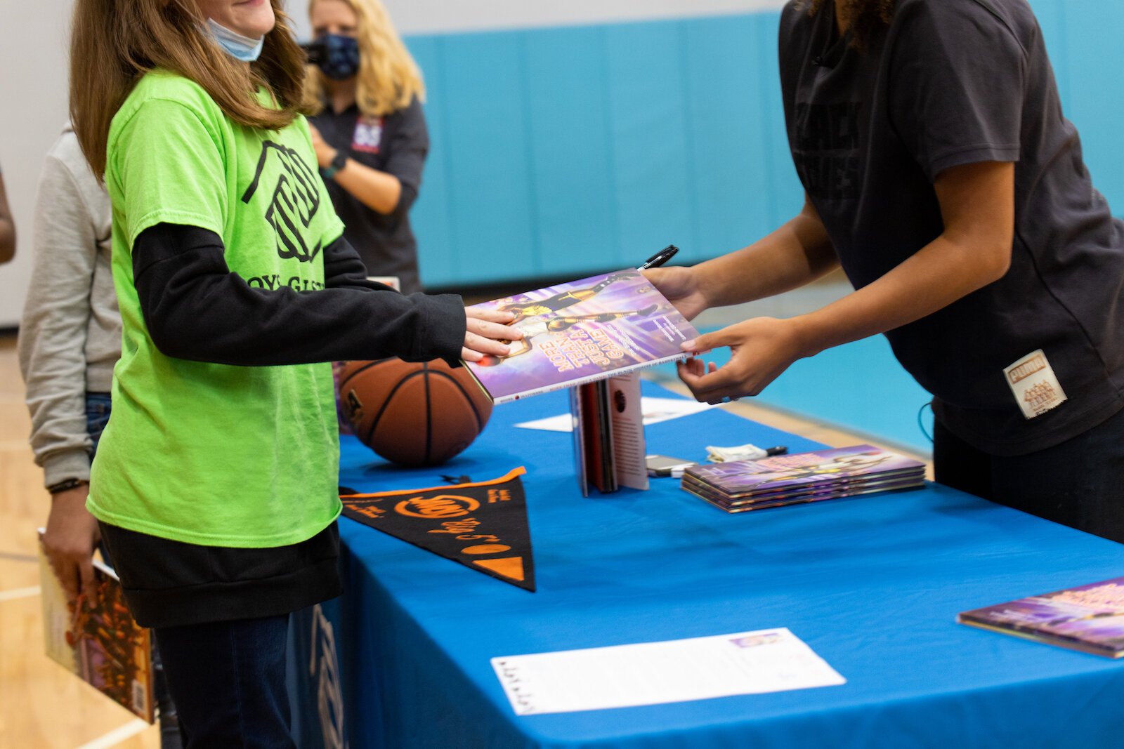 Madison Moore, a Fort Wayne-raised author of "More Than Just a Game: The Black Origins of Basketball," signs copies of her book at the Fort Wayne Boys & Girls Club.