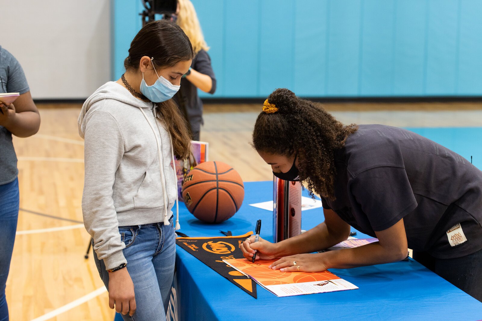 Madison Moore, a Fort Wayne-raised author of "More Than Just a Game: The Black Origins of Basketball," signs copies of her book at the Fort Wayne Boys & Girls Club.