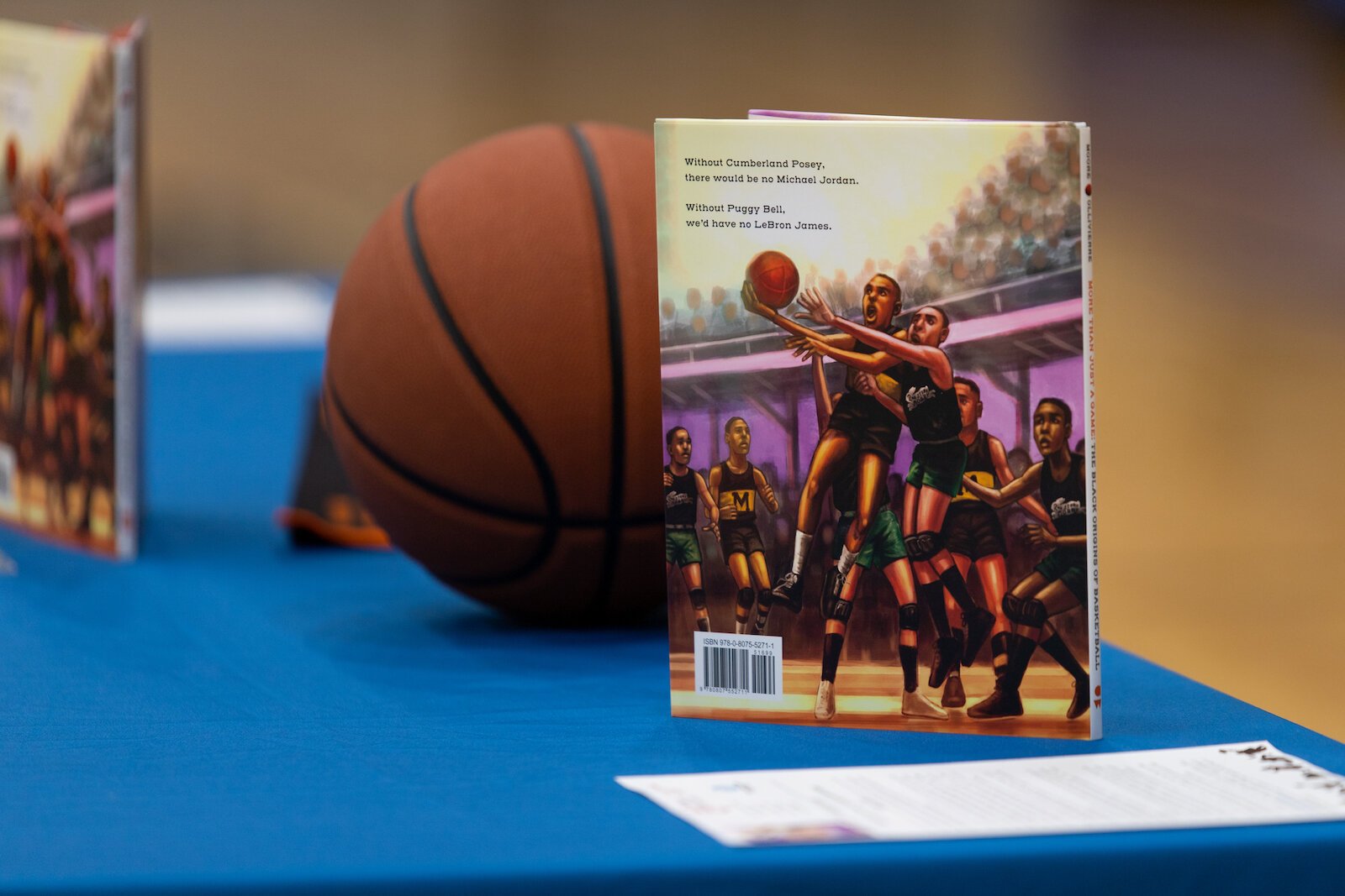 Madison Moore, a Fort Wayne-raised author of "More Than Just a Game: The Black Origins of Basketball," signs copies of her book at the Fort Wayne Boys & Girls Club.